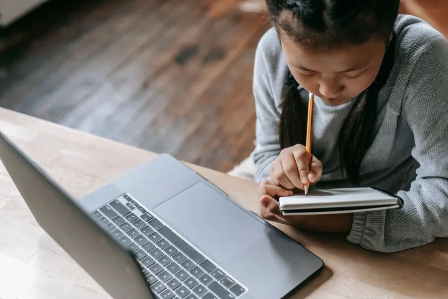 A woman taking notes at her laptop